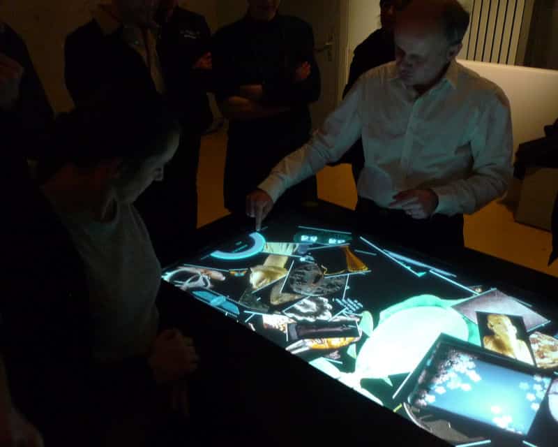 Homme présentant l'outil Museotouch autour d'une table tactile
